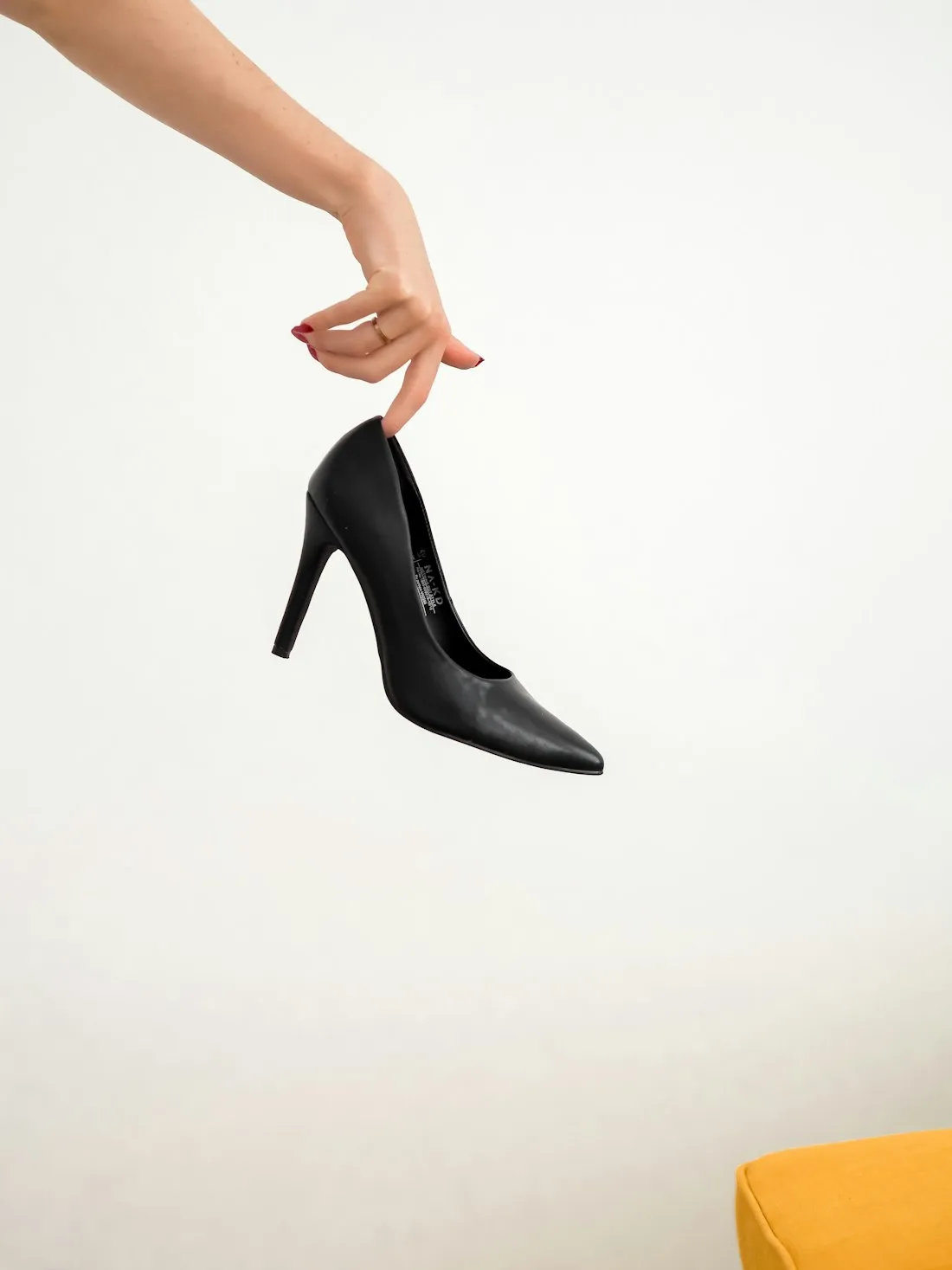 Klassischer schwarzer Lederpump, elegant in der Hand gehalten